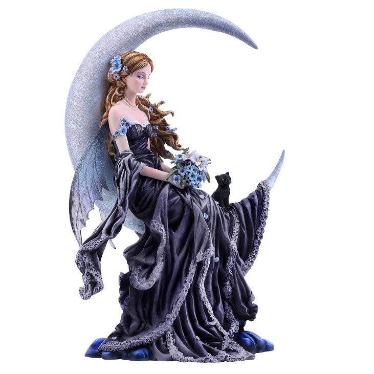 A statuette of a beautiful fairy with long brown hair and blue dragonfly wings, wearing blue flowers in her hair and a long blue dress and holding a bouquet of blue flowers, resting sleepily in the curve of the crescent moon, a black kitten by her side.